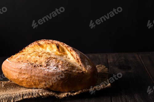 Preview: Bakery - gold rustic crusty loaves of bread and buns on black background.