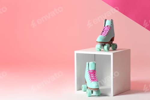 Preview: Pair of vintage roller skates and storage cube on color background. Space for text