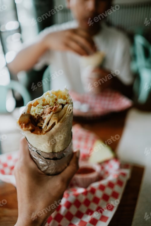 Preview: Hand holding burrito food lunch dinner first person point of view eating together friends Mexican