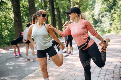 Preview: Professional warm up exercises. Group of runners are together outdoors