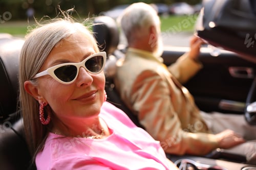 Preview: Senior couple enjoying cabriolet ride in city, selective focus