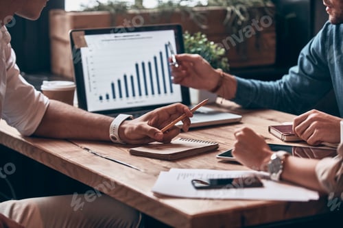 Preview: Close up of modern people analyzing data on laptop while working in the office