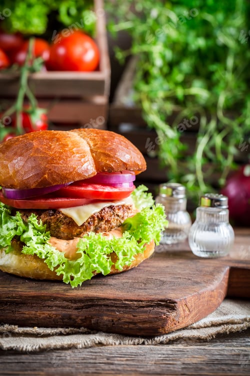 Preview: Homemade burger with vegetables on old wooden table