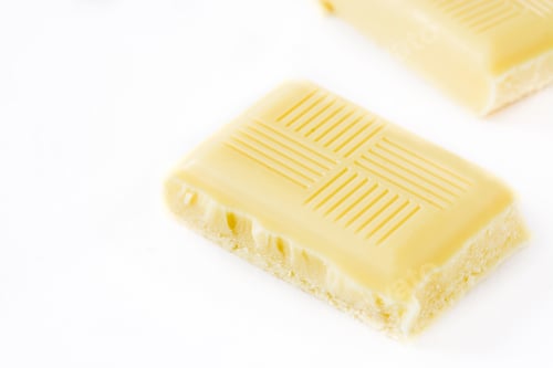 Preview: White chocolate bar pieces resting on white background