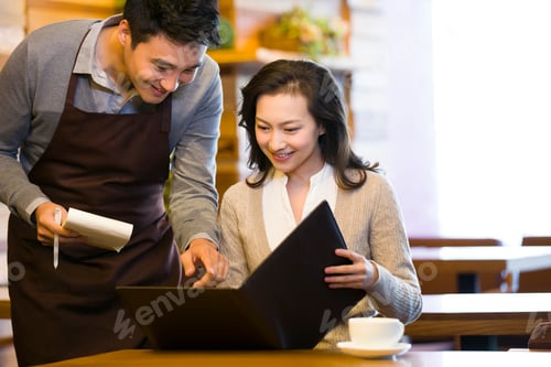 Preview: Waiter taking order from woman at restaurant