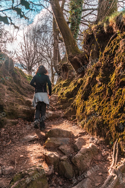 Preview: A young girl in black in the mud ramps of the trail of Mount Adarra in Guipuzcoa. Basque Country