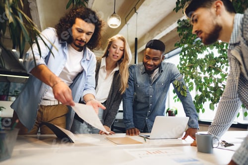 Preview: Smiling multiracial coworkers working together at office meeting, have a discussion