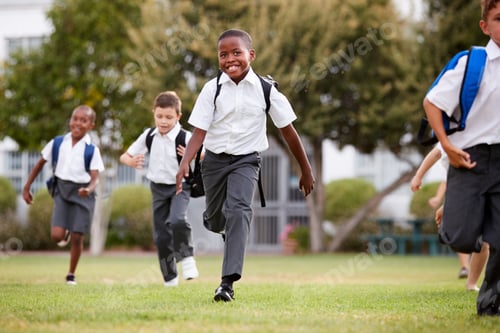 Preview: Excited Elementary School Pupils Wearing Uniform Running Across Field At Break Time