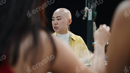 Preview: Thai friends dining at restaurant, bald woman enjoying traditional moo krata hotpot