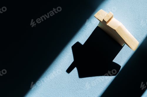 Preview: Miniature wooden house with shadows on blue background