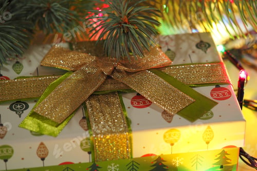Preview: New Year's gift. Festive gift packaging against the background of the Christmas tree.