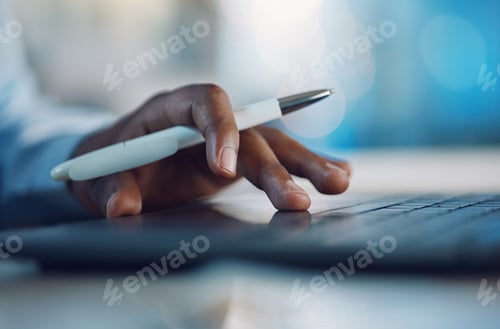 Preview: Closeup hands of african man holding a pen and working on a laptop. African american business man u