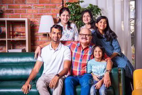 Preview: Happy Indian asian family consists of grandparents, parents, kids posing for photo sitting on sofa
