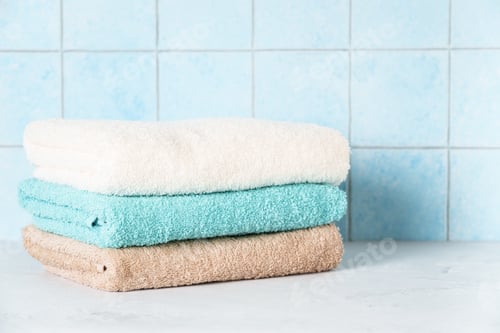 Preview: Clean towels in the laundry against blue wall.