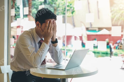 Preview: Asian businessman is have a problem with stressful work and the laptop is placed table on the office