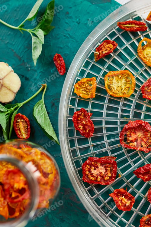 Preview: Homemade sun dried tomatoes with herbs, on the sieve from dryer.