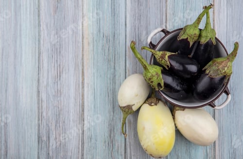 Preview: top view of black nadia eggplants in bowl with white and yellow ones on wooden background with copy