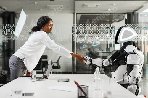 Preview: smiling african american businesswoman shaking hands with robot in office