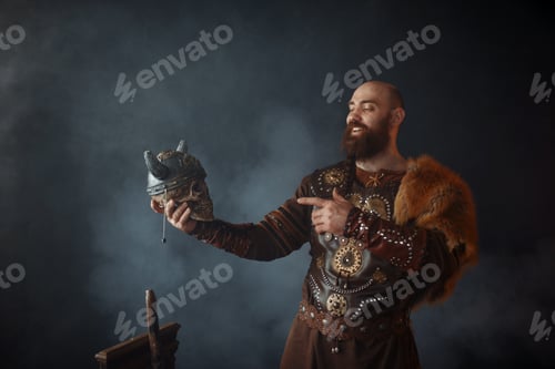 Preview: Smiling viking holds enemy's skull in helmet