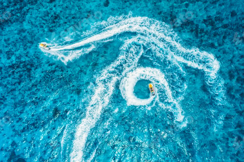 Preview: Aerial view of floating water scooter in blue water at sunset