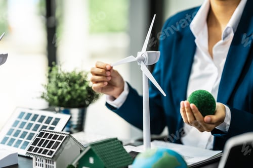 Preview: A businesswoman is reviewing contract papers at her desk in a sustainable house and condo