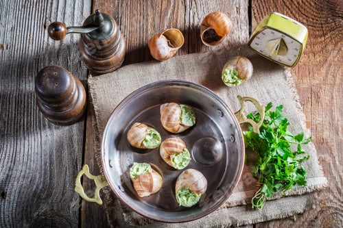 Preview: Homemade snails with garlic butter on old wooden table