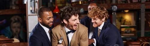 Preview: bachelor party banner, excited interracial men congratulating friend in bar, best men tickling groom
