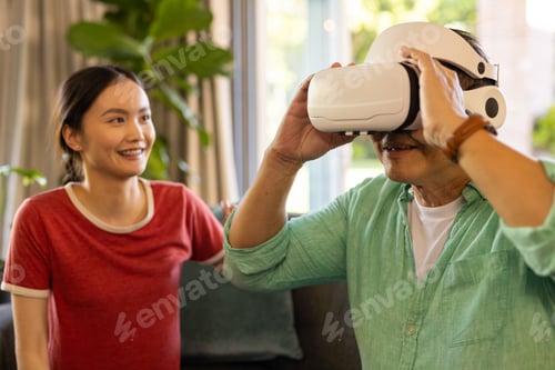 Preview: Using VR headset, father exploring virtual reality while daughter smiling nearby