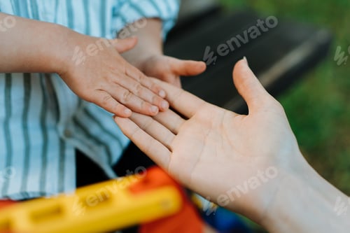 Preview: Mother and child are touching palms, expressing love.