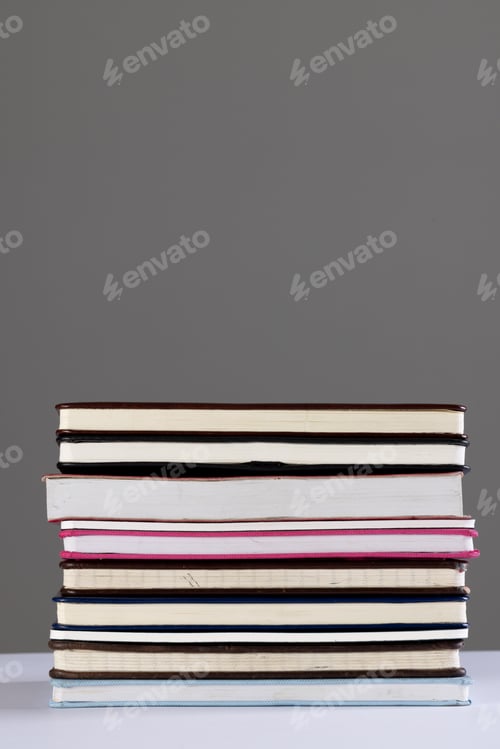 Preview: Close up of stack of books and notebooks with copy space on grey background