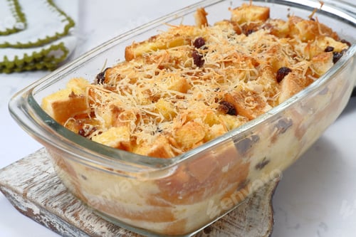 Preview: Homemade bread butter pudding with raisins and grated cheese as topping