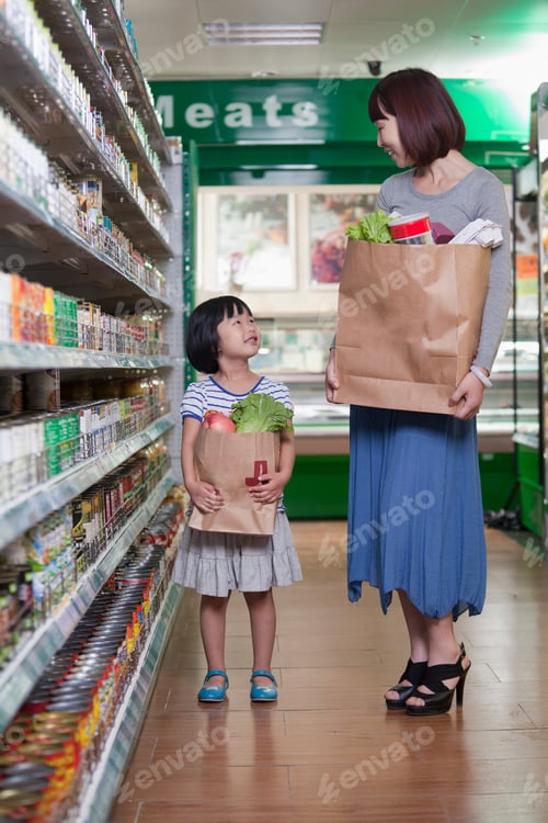 Preview: Mother and daughter holding grocery bags in supermarket, Beijing