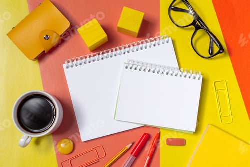 Preview: Notebooks, coffee, and stationery on a colorful table for work or study tasks