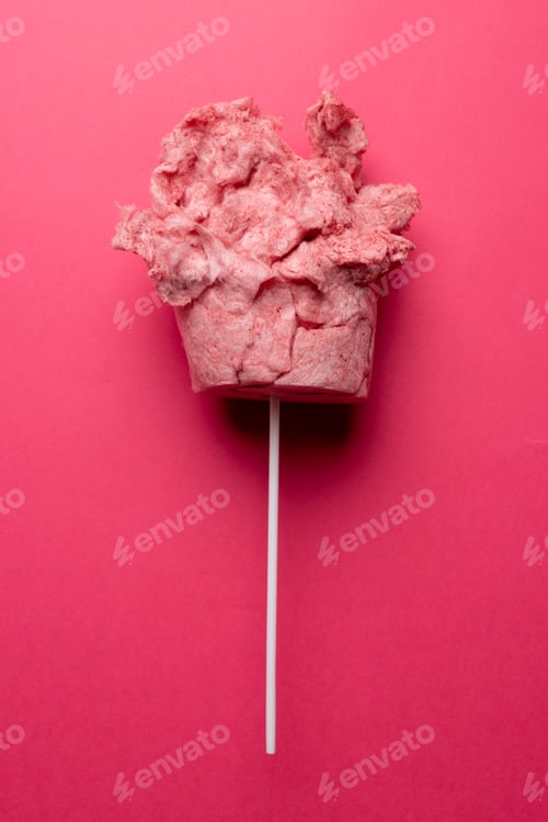 Preview: Vertical image of homemade pink candy floss on stick, on pink background with copy space