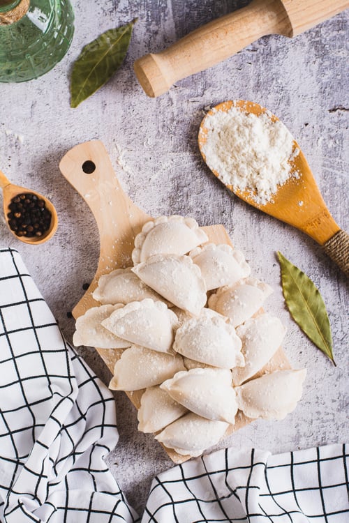 Preview: Frozen raw dumplings with potatoes on a cutting board on the table top and vertical view