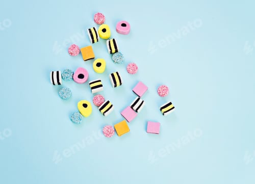 Preview: Colored jelly candy scattered on blue background, abstract background. Blue candy, pastel minimalism