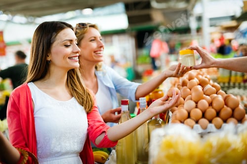 Preview: Young happy women shopping vegetables and fruits on the market