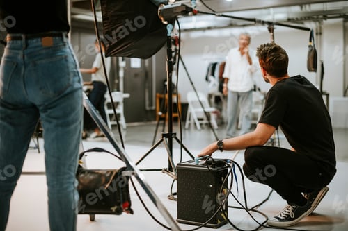 Preview: Young man with a battery pack in a studio