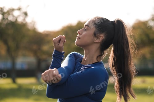 Preview: Portrait of sport woman stretching in a park with closed eyes.