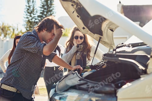 Preview: I shouldve insured it. Shot of a young man looking under the hood of a broken down car.