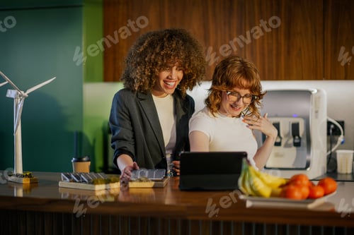 Preview: Experts smiling at tablet at office and working on sustainability.