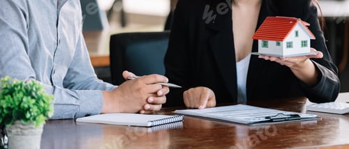 Preview: Real estate agent sales manager holding house model to customer after signing rental lease contract