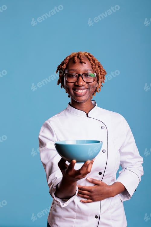 Preview: Happy cooker showing a container, looking at the camera