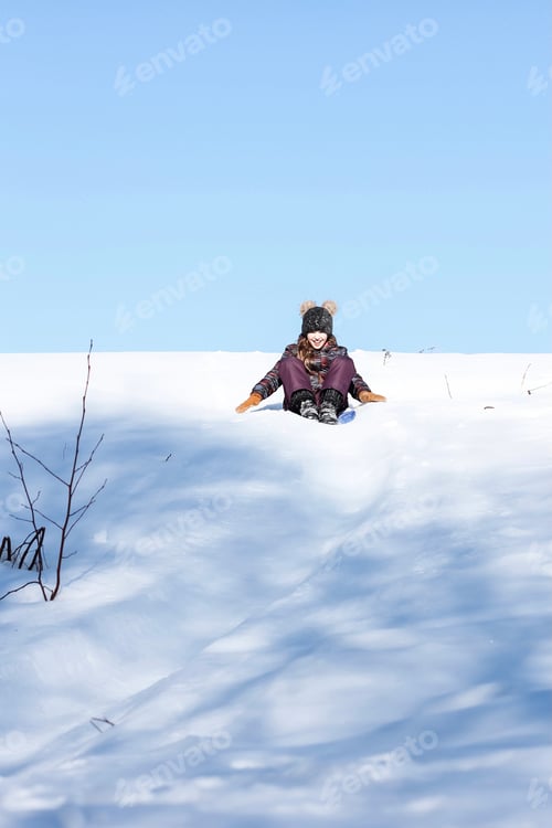 Preview: A cute ten years old teenage girl having fun on snow tube on a winter day. Wintertime, activity. N