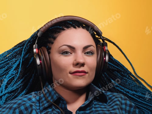 Preview: Beautiful young girl with african blue braids is listening to music with headphones and dancing
