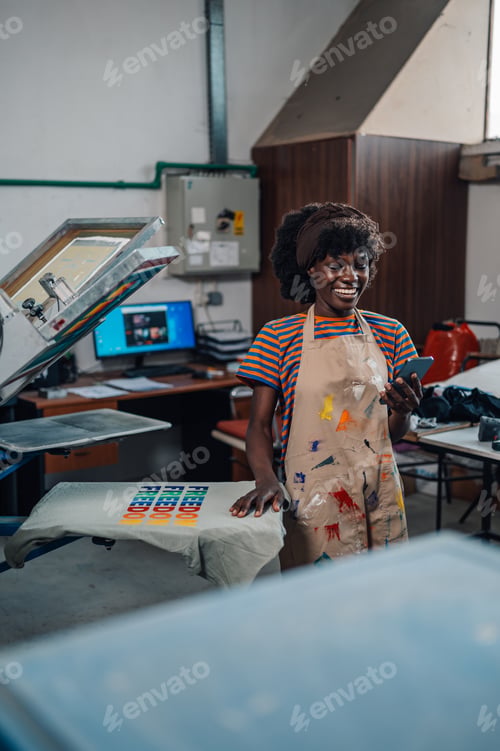 Preview: Happy interracial print shop worker using cellphone at facility.
