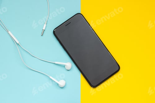 Preview: Smartphone with headphones on a blue yellow background