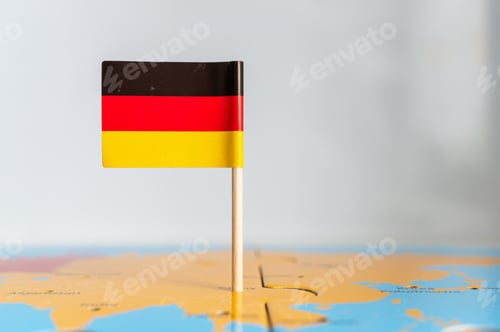 Preview: Small rotated flag of Germany on a wooden stick fixed on the globe