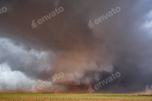 Preview: A Monster Wedge Tornado near Morton, clouds gathering in the sky above fields in a flat landscape.