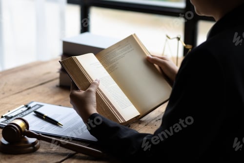 Preview: Lawyer and legal justice, Lawyer working on paperwork and reading law book in office.